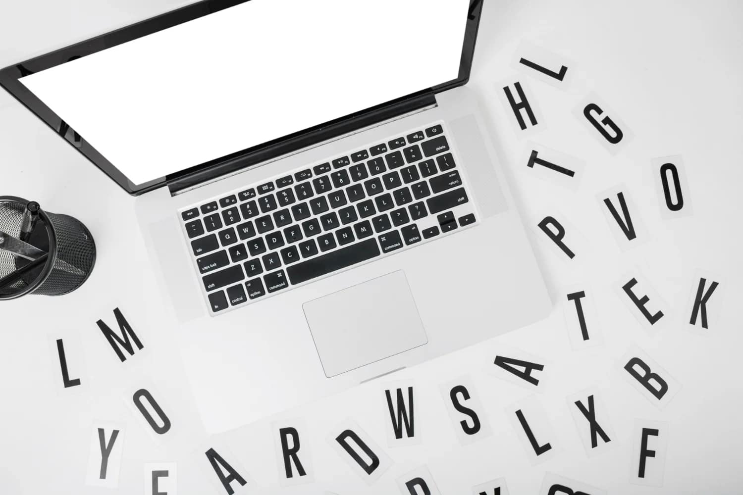 Ordinateur portable entouré de lettres, illustrant l’importance d’un contenu clair pour un site WordPress optimisé SEO