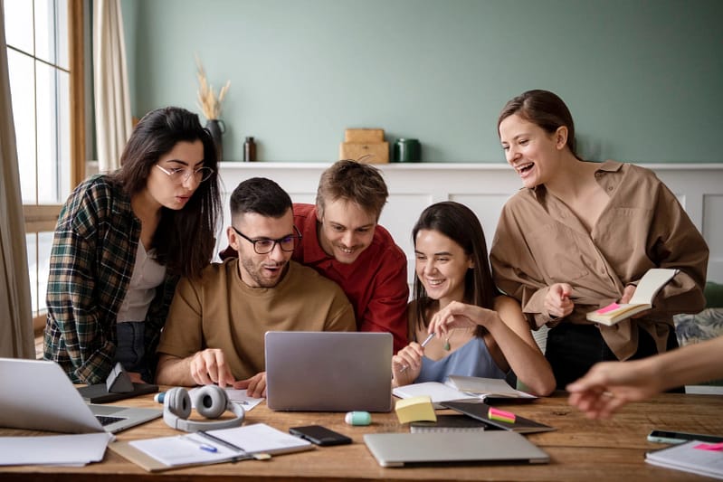 Groupe de personnes regardant ensemble un site internet sur un ordinateur portable, illustration générique pour la section À propos.